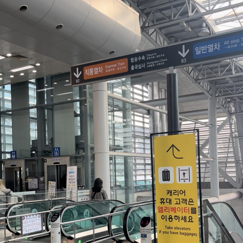 ソウル駅構内の空港鉄道AREX方面を示す案内表示とエスカレーター