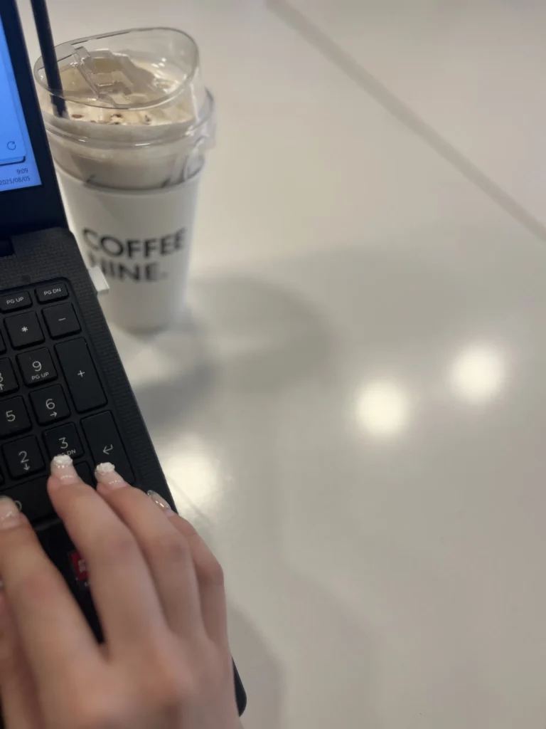 新羅ステイ光化門のデスクでノートパソコンとアイスコーヒーを置いて作業する様子