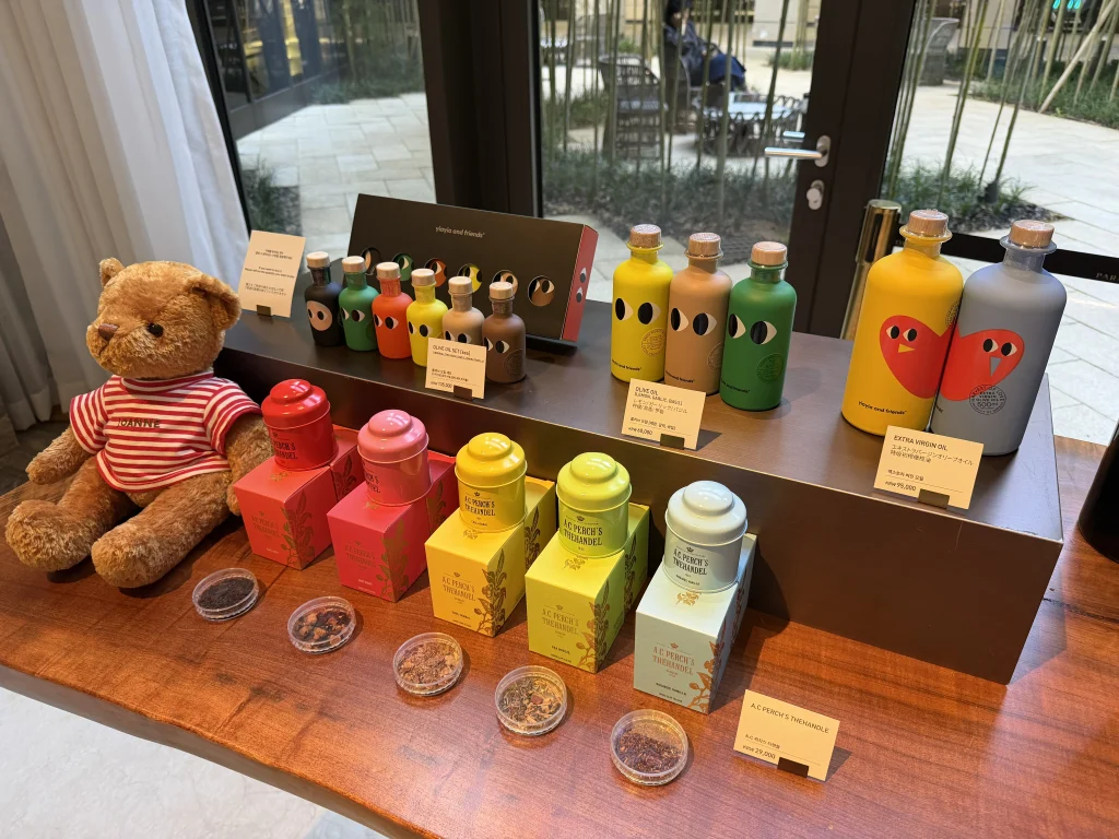 パラダイスシティのガーデンカフェに並ぶ紅茶、オリーブオイル、テディベアなどのギフト商品