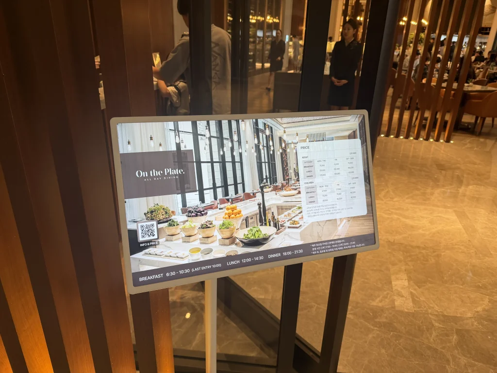パラダイスシティのオン・ザ・プレート入口に掲示された朝食料金と営業時間の案内