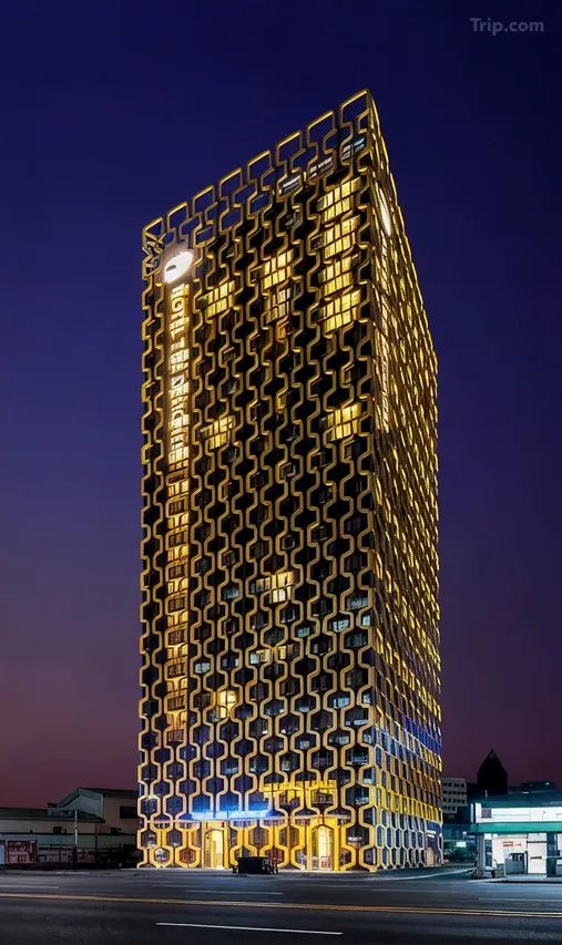 韓国ソウル・東大門のホテルザ・デザイナース東大門の夜景。幾何学模様の外壁が黄金色にライトアップされた高層ホテルの外観。