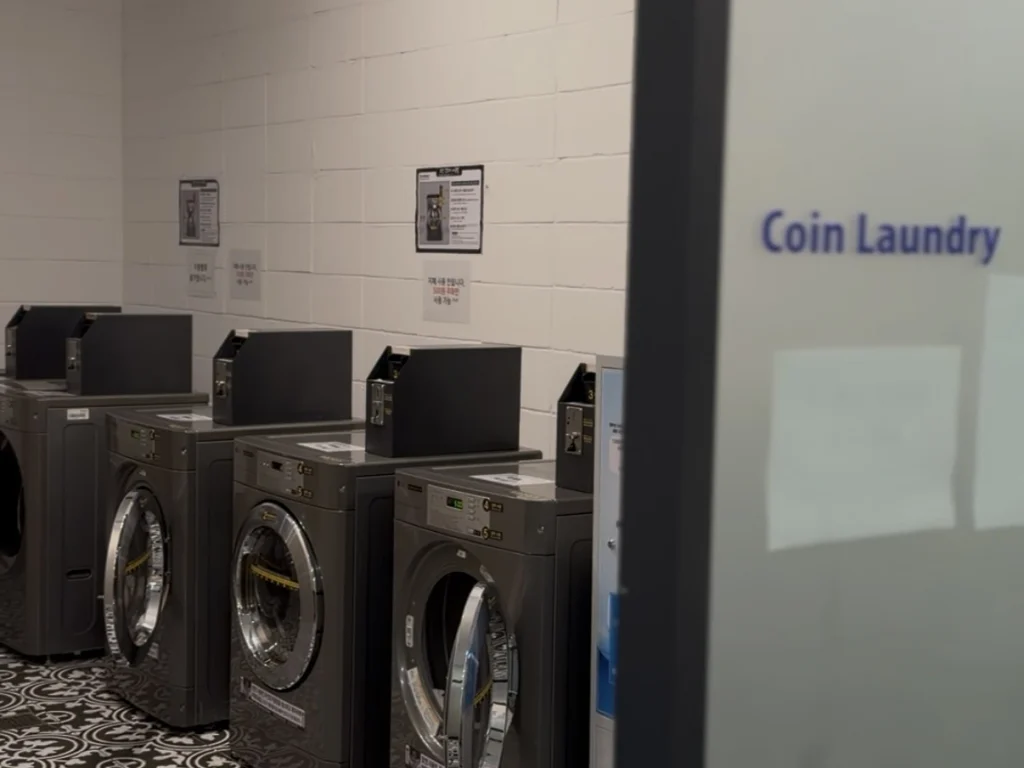 JKブロッサムホテルの地下コインランドリーに並ぶ洗濯機