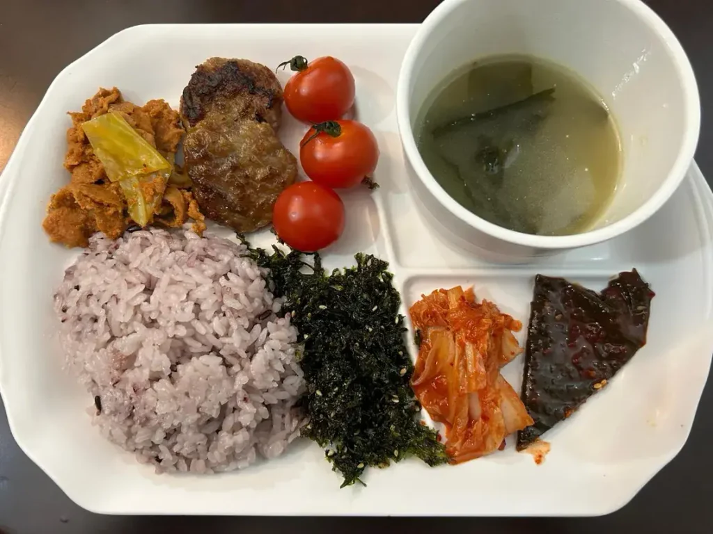 東横INNソウル江南の朝食。雑穀ご飯やキムチ、韓国のり、肉料理、ミニトマト、スープなどが並ぶ韓国風の朝食プレート。